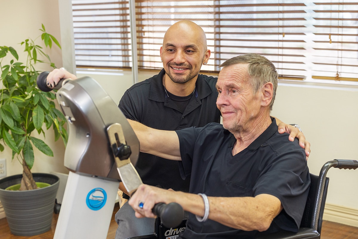 Rehab therapist with a resident in the gym at the Sunrise Post Acute facility