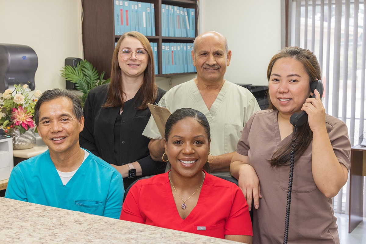 Several caregivers smiling at the nurse's station